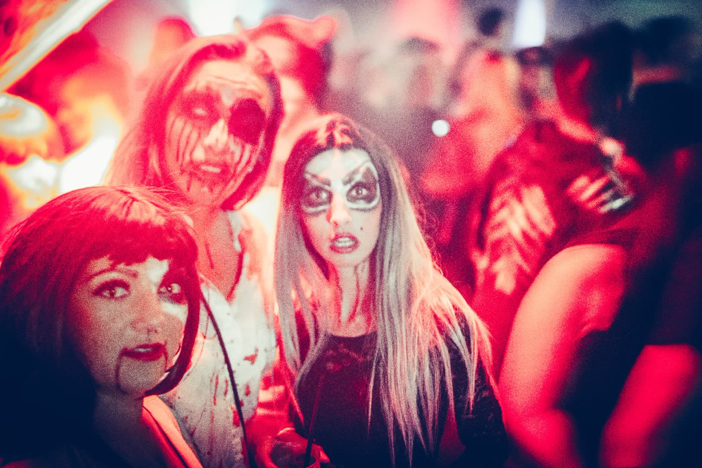 Gruppe mit Horror-Make-up im roten Licht