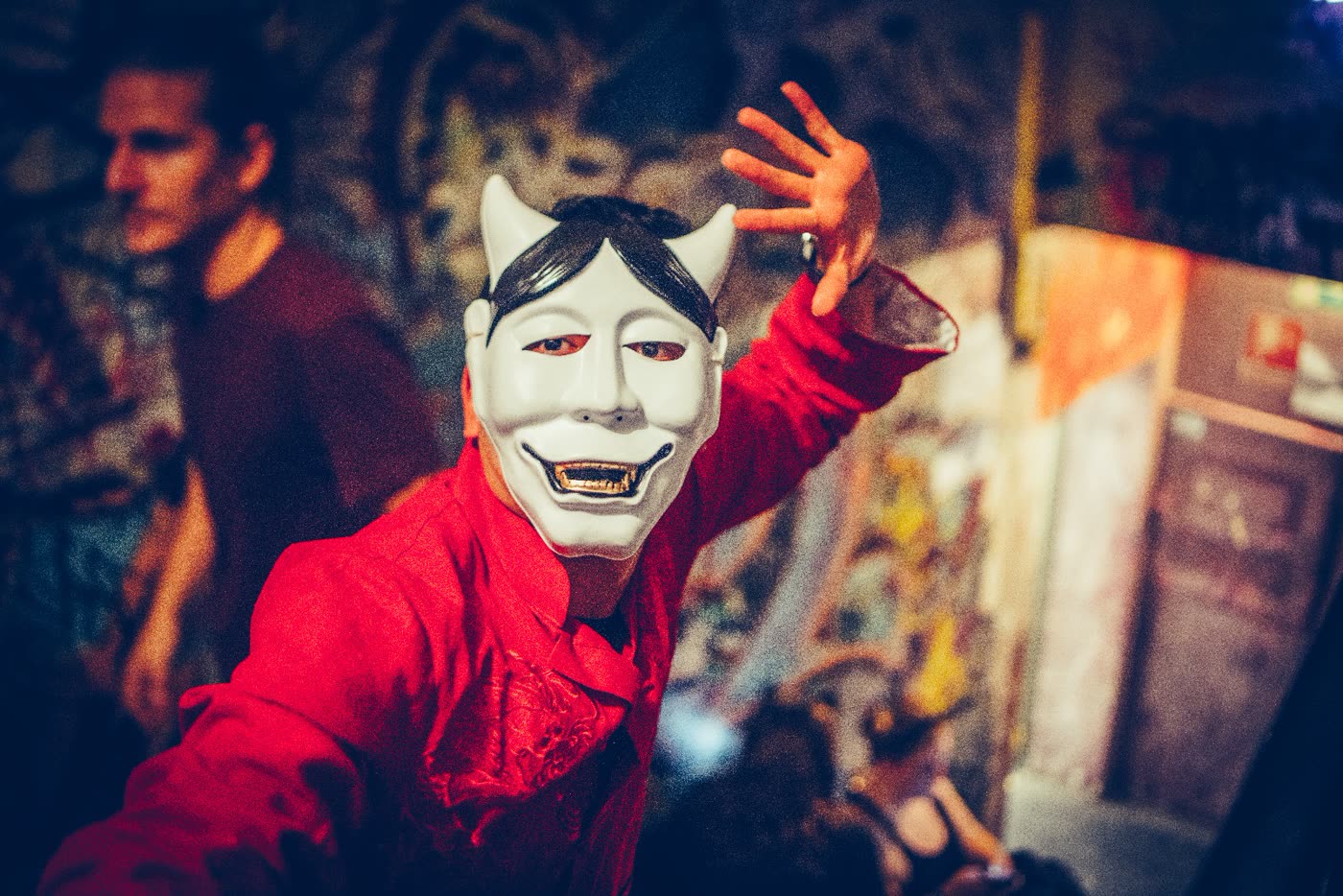 Gast mit Maske und roter Jacke